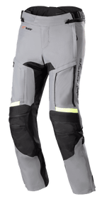 Alpinestars Bogota' Pro Drystar® 3 Seasons Pants, ciemnoszare i czarne spodnie motocyklowe Adventure Touring, neonowożółte fluorescencyjne akcenty odblaskowe, zapinane na zamek panele wentylacyjne na udach, elastyczne panele harmonijkowe na kolanach oraz wzmocnione panele ochronne.