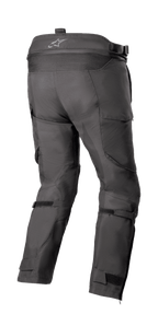 Alpinestars Bogotá Pro Drystar® 4 Seasons Pants - Short, turystyczne spodnie motocyklowe adventure, czarne, widok z tyłu pokazujący wysoką talię z logo, elastyczny panel harmonijkowy, regulowane paski na łydkach i techniczną konstrukcję tekstylną.