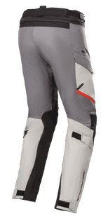 Alpinestars Andes V3 Drystar® Pants, motocyklowe spodnie turystyczne, jasnoszare i ciemnoszare, z czarnymi panelami wzmacniającymi i czerwonym akcentem na kieszeni, regulowane paski w talii i na łydkach, wytrzymała konstrukcja tekstylna do jazdy adventure