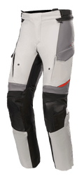 Spodnie Alpinestars Andes V3 Drystar®, motocyklowe spodnie turystyczne adventure, kolor jasnoszary i ciemnoszary z czarnymi akcentami, wzmocnione panele na kolanach, kieszenie typu cargo, regulowany pasek w talii, wytrzymały materiał tekstylny z czerwonymi detalami