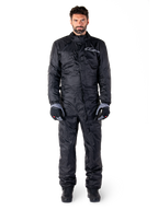 Alpinestars Hurricane Rain V2 Suit, pełny motocyklowy kombinezon przeciwdeszczowy w kolorze czarnym, wodoodporna odzież ochronna z wysokim kołnierzem i przednim zapięciem uszczelniającym, białe logo na piersi, prezentowany z czarno-szarymi rękawicami i butami