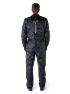 Alpinestars Hurricane Rain V2 Suit, czarny jednoczęściowy wodoodporny kombinezon motocyklowy, widok z tyłu z dużym pionowym napisem i logo Alpinestars, lekki marszczony materiał z elastycznym pasem i mankietami, zaprojektowany do ochrony podczas jazdy w deszczu.
