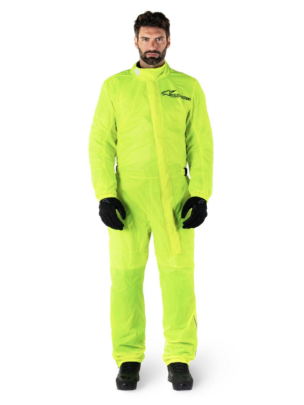 Alpinestars Hurricane Rain V2 Suit, motocyklowy kombinezon przeciwdeszczowy, żółty neonowy, męski model w pełnej ochronie ciała z czarnymi rękawicami i butami, wysoki kołnierz z przednią klapą, odblaskowe logo na klatce piersiowej, wodoodporna odzież o wysokiej widoczności
