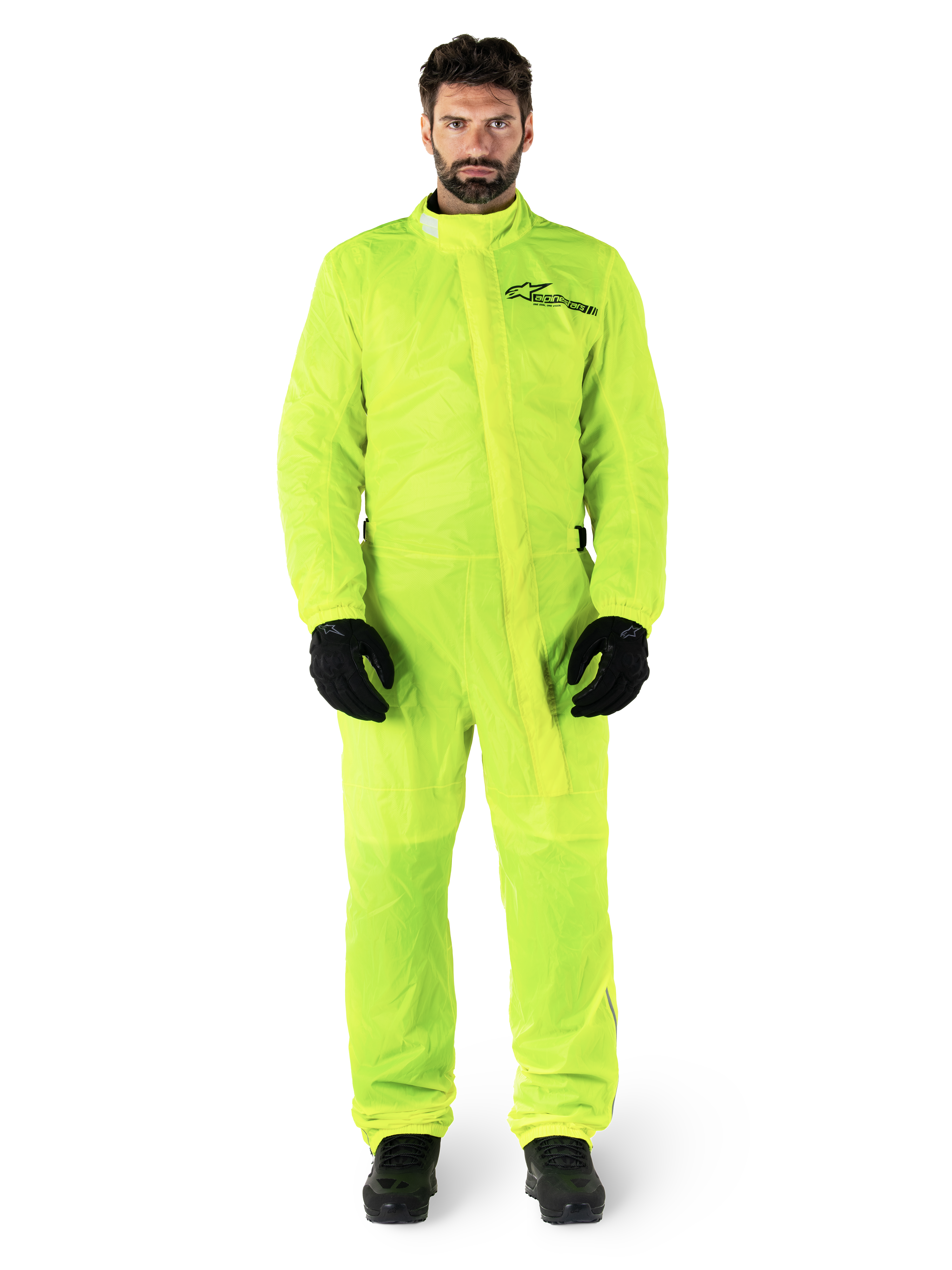 Alpinestars Hurricane Rain V2 Suit, motocyklowy kombinezon przeciwdeszczowy, żółty neonowy, męski model w pełnej ochronie ciała z czarnymi rękawicami i butami, wysoki kołnierz z przednią klapą, odblaskowe logo na klatce piersiowej, wodoodporna odzież o wysokiej widoczności