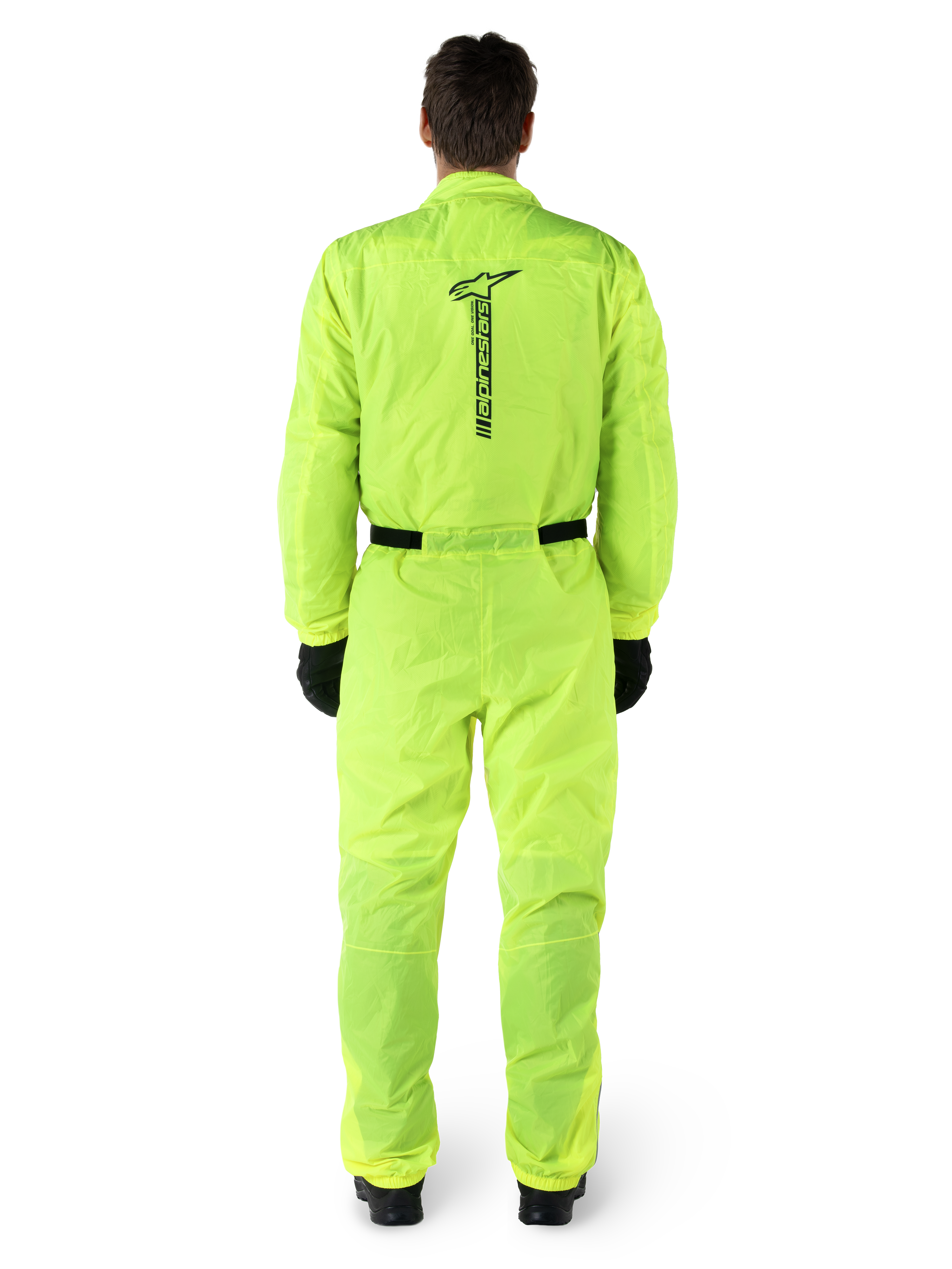 Alpinestars Hurricane Rain V2 Suit, jednoczęściowy motocyklowy kombinezon przeciwdeszczowy, żółty fluo, widok z tyłu z pionowym czarnym logo Alpinestars, elastyczny pas i mankiety, noszony z czarnymi rękawicami i butami, wodoodporna i wiatroodporna odzież motocyklowa
