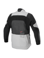 Kurtka Alpinestars AMT-7 Air, widok z tyłu, kolor Tan i Dark Shadow, techniczna kurtka motocyklowa z dużym panelem siatkowym MATRYX® na plecach, napisem „Alpinestars Motion Technology” i czerwonym logo, zaprojektowana do letniej turystyki adventure
