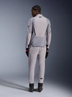 Kurtka Alpinestars Aeroshell Airflow, Mid Gray Anthracite, widok od tyłu na modelu, techniczne panele z siatki i laserowo perforowane strefy wentylacyjne, noszona z pasującymi szarymi spodniami i czarnym sprzętem motocyklowym, sportowy krój zapewniający wysoką wydajność.