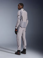 Kurtka Alpinestars Aeroshell Airflow w kolorze Mid Gray Anthracite, noszona z dopasowanymi spodniami i czarnymi rękawicami wyścigowymi, widok z tyłu ukazujący panele perforowane laserowo i sportowy krój, profesjonalna odzież motocyklowa