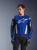 Alpinestars T-GP Air Jacket, sportowa tekstylna kurtka motocyklowa, jasnoniebieska i granatowa z białymi akcentami, z dużym logo gwiazdy na piersi, siateczkowe panele wentylacyjne, noszona przez modela z pasującymi rękawicami i czarnymi spodniami