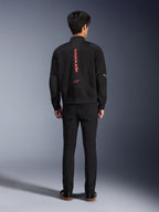 Kurtka Alpinestars Flight Air w kolorze Black Bright Red, widok z tyłu miejskiej kurtki motocyklowej typu bomber, z pionowym czerwonym napisem i logo Alpinestars na plecach, lekka konstrukcja z siatki 3D, zestawiona z czarnymi spodniami dla nowoczesnego wyglądu.