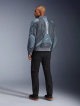 Alpinestars Flight Air Jacket, kurtka motocyklowa Storm Gray, widok z tyłu, z panelami wentylacyjnymi z siatki 3D i pionowym białym logo Alpinestars, noszona z czarnymi spodniami i czarnymi sneakersami, miejski styl commuter