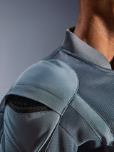 Zbliżenie na kurtkę Alpinestars Flight Air w kolorze Storm Gray, prezentujące zewnętrzną kieszeń na ochraniacz ramienia z widocznym pancerzem o strukturze plastra miodu, panele wentylacyjne z siatki 3D i żebrowany kołnierzyk do technicznej jazdy miejskiej