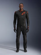 Alpinestars Viper Air V4 Jacket w kolorze Black Red Fluo, noszona przez modela z dopasowanymi czarnymi spodniami i rękawicami, z panelami z siatki dla lepszego przepływu powietrza i wyraźnym czerwonym logo Alpinestars na klatce piersiowej, sportowa odzież motocyklowa.