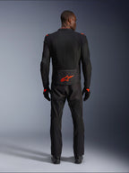 Kurtka Alpinestars Viper Air V4, Black Red Fluo, widok z tyłu na modelu, zestaw z dopasowanymi czarnymi spodniami i rękawicami motocyklowymi, jaskrawe neonowe czerwone logo na dole pleców, siateczkowa konstrukcja zapewniająca przepływ powietrza, sportowy krój do jazdy szosowej