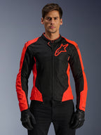 Alpinestars Viper Air V4 Jacket, kurtka motocyklowa wyścigowa, czerwona fluo i czarna, noszona przez modela w czarnych rękawicach, panele z siatki technologicznej dla wentylacji, sportowy design z logo gwiazdy Alpinestars na klatce piersiowej