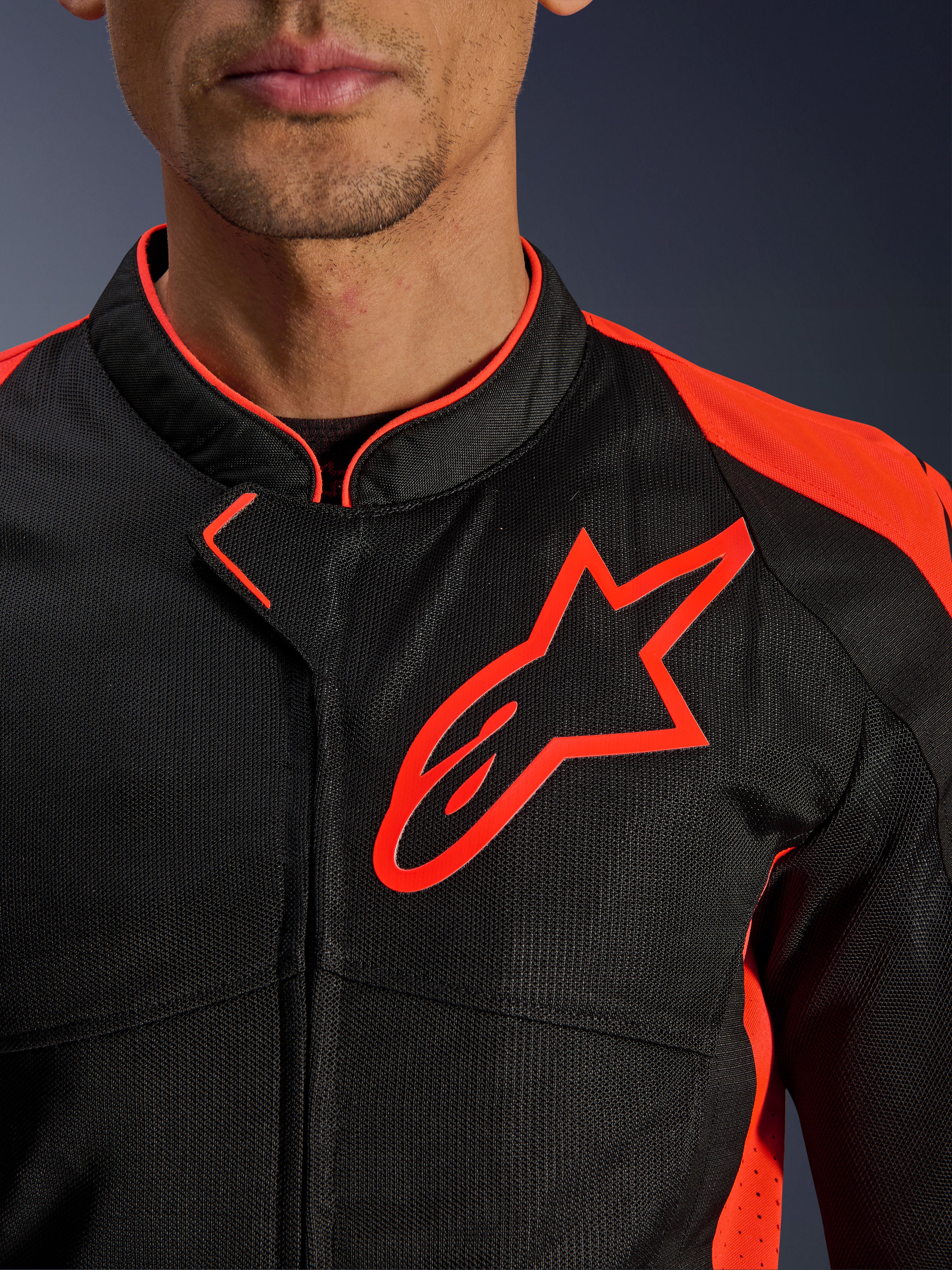 Alpinestars Viper Air V4 Jacket w kolorze Red Fluo Black, zbliżenie na klatkę piersiową i kołnierz, czarna konstrukcja z siatki technologicznej, wyraźne czerwone logo Alpinestars, jaskrawoczerwone akcenty na ramionach