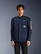 Alpinestars Dice Jacket, miejska kurtka motocyklowa, ciemnoniebieska i czarna, wzór kurtki terenowej z wieloma kieszeniami, spiralna naszywka na piersi i białe logo Alpinestars na rękawach, nowoczesna odzież jeździecka inspirowana stylem roboczym