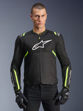 Alpinestars T-Sps Air V2 Jacket w kolorze czarno-żółtym neonowym, męski model ubrany w wentylowaną kurtkę tekstylną z panelami z siatki i białym logo na piersi, czarne rękawice motocyklowe, miejska odzież motocyklowa