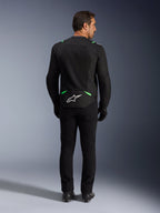 Kurtka Alpinestars T-SPS Air V2, kurtka motocyklowa, czarna z zielonymi akcentami fluo, widok z tyłu z białym logo w dolnej części pleców, zestawiona z czarnymi spodniami i butami, wentylowana konstrukcja mesh do jazdy sportowej