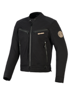 Alpinestars Bruiser Jacket, czarna miejska kurtka motocyklowa, kieszenie na klatce piersiowej i boczne zapinane na zamek, złoty branding i spiralna naszywka Oscar na ramieniu, tekstylny design inspirowany odzieżą roboczą