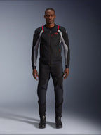 Alpinestars Troop-Air Pro Jacket, techniczna kurtka motocyklowa, czarna, popielato-szara i jaskrawoczerwona, z panelami z siatki i czerwonymi akcentami, noszona przez modela z czarnymi spodniami i butami motocyklowymi, nowoczesny miejski design z techniczną wentylacją.