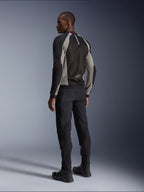 Model w kurtce Alpinestars Troop-Air, widok od tyłu, kolorystyka Black Ash Gray z jaskrawoczerwonymi akcentami, techniczna konstrukcja z siatki mesh dla optymalnej wentylacji, czarne spodnie motocyklowe i buty, współczesny styl miejski