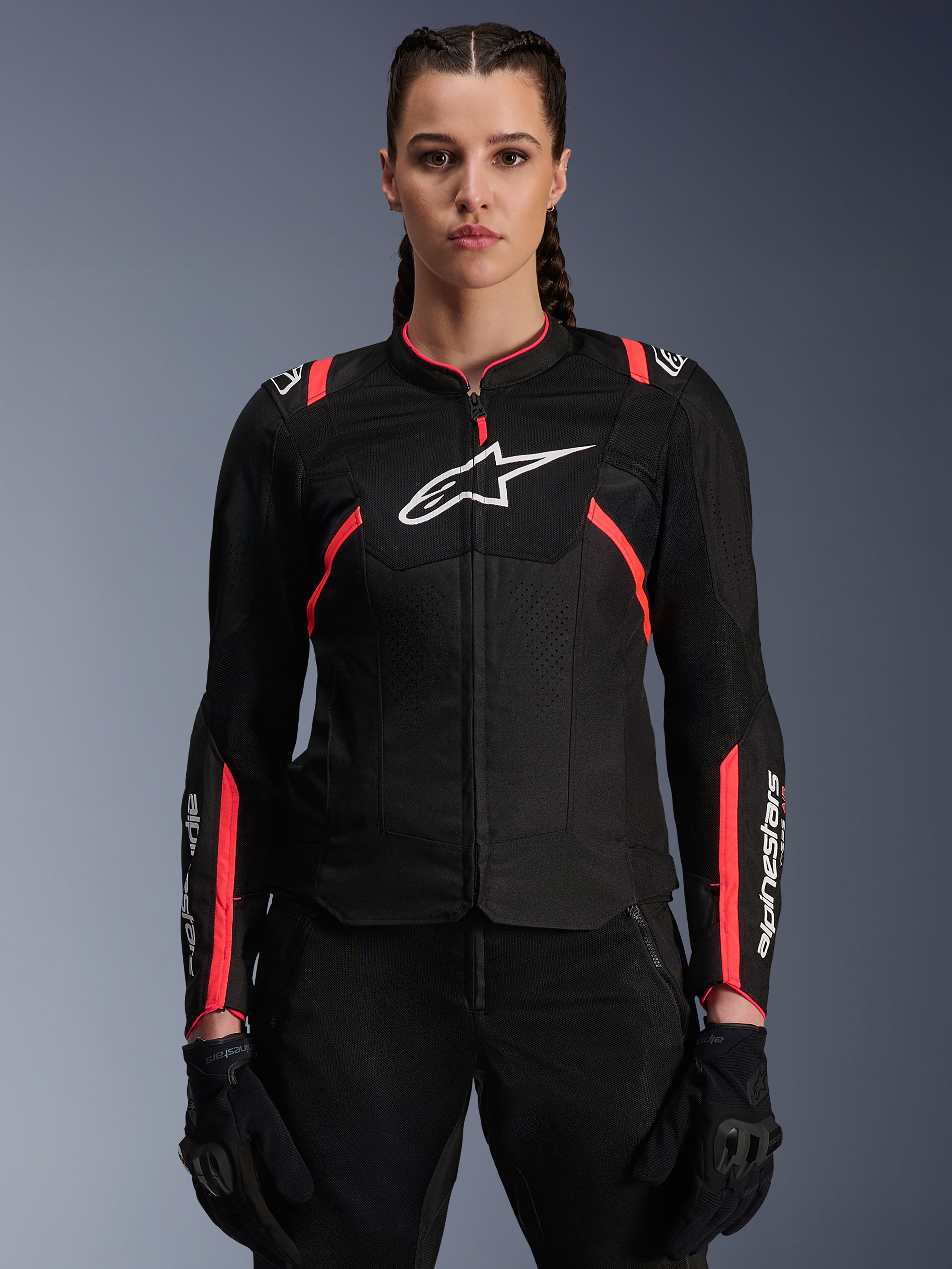 Alpinestars Stella T-SPS Air V2, damska kurtka motocyklowa, czarna z różowymi akcentami Diva Pink, wentylowana konstrukcja tekstylna, białe logo, różowe akcenty inspirowane wyścigami na ramionach i rękawach, prezentowana przez modelkę