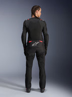 Alpinestars Stella T-SPS Air V2 Jacket, damska tekstylna kurtka motocyklowa, czarna z różowymi akcentami Diva Pink, widok z tyłu na modelce z warkoczami, duże panele z siatki dla wentylacji, białe logo Astars w dolnej części pleców, w zestawie z dopasowanymi czarnymi spodniami motocyklowymi.