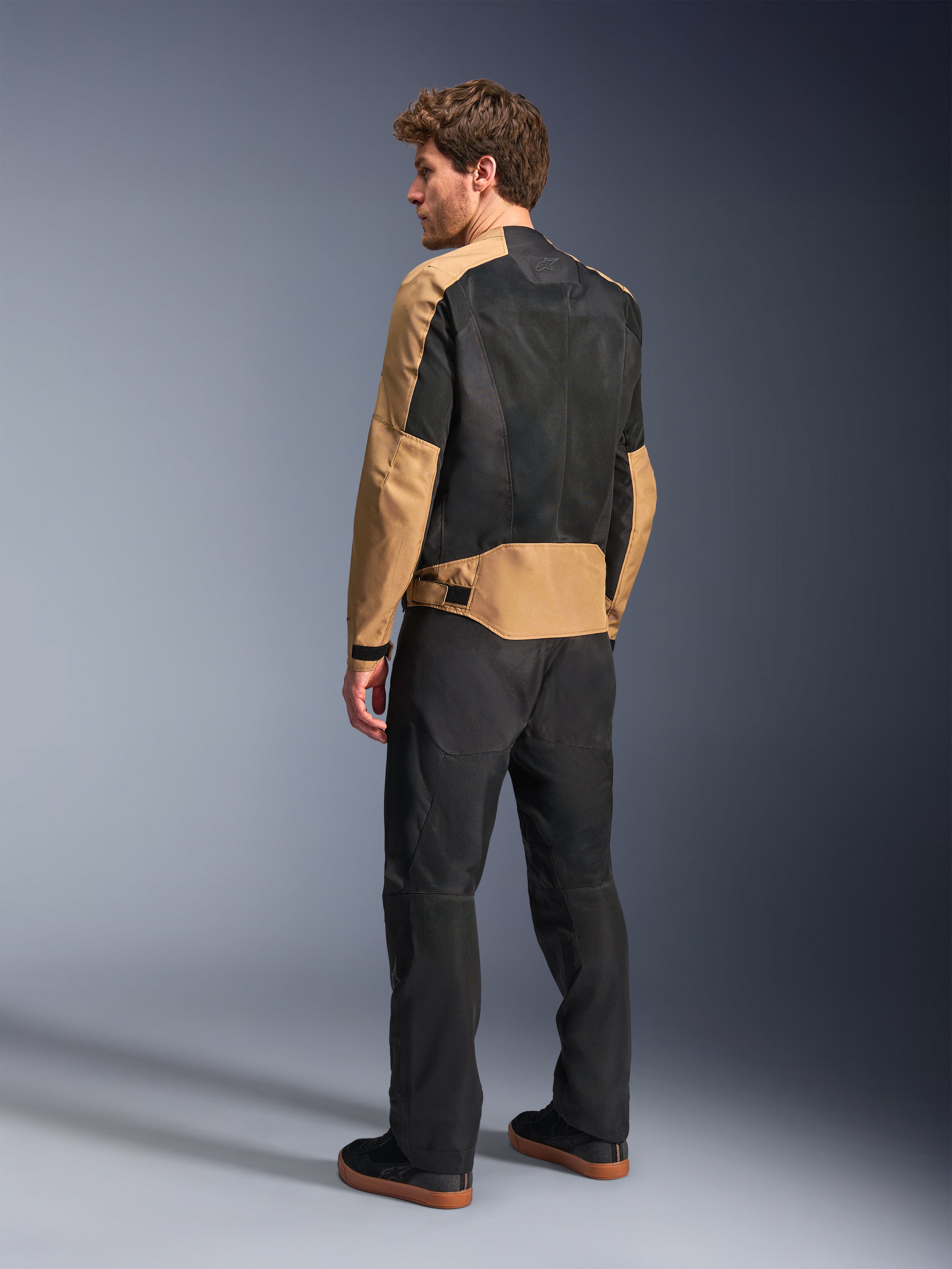 Alpinestars C-1 Air, męska miejska kurtka motocyklowa, piaskowa i czarna, widok z tyłu na modelu ukazujący panele z siatki tech mesh, letnia odzież tekstylna.