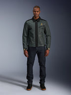 Kurtka Alpinestars Ignite Air w kolorze Urban Gray Black Blue, kurtka motocyklowa w stylu Harrington z kołnierzykiem koszulowym i siateczkową konstrukcją, noszona przez mężczyznę w ciemnych jeansach i czarnych sneakersach, miejski streetwear dla motocyklistów.