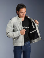 Kurtka Alpinestars Circal-1 Air, kolor Metal Gray, rozpięta, ukazująca wewnętrzną podszewkę z siateczki i detale kieszeni, noszona przez modela w czarnym t-shircie z logo i niebieskich jeansach, miejski styl motocyklowy