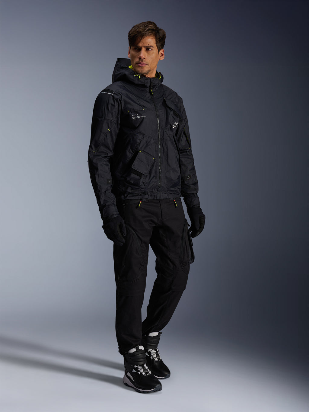 Kurtka Alpinestars Mogress Air, miejska kurtka motocyklowa, czarna z akcentami w kolorze Lime Punch i białym, noszona z czarnymi spodniami motocyklowymi, rękawicami oraz czarno-białymi butami, nowoczesny design inspirowany stylem utility.