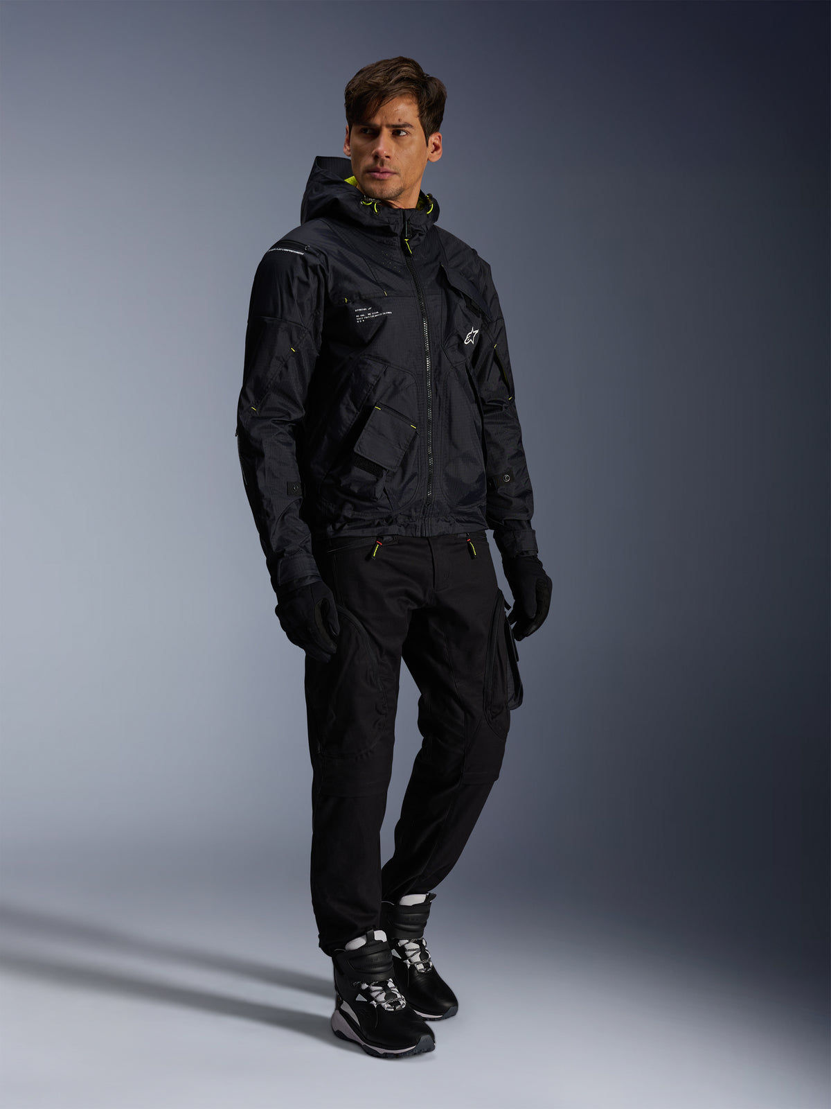 Kurtka Alpinestars Mogress Air, miejska kurtka motocyklowa, czarna z akcentami w kolorze Lime Punch i białym, noszona z czarnymi spodniami motocyklowymi, rękawicami oraz czarno-białymi butami, nowoczesny design inspirowany stylem utility.
