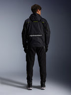 Alpinestars Mogress Air Jacket, miejska kurtka motocyklowa, widok z tyłu w kolorze czarnym z limonkowymi i białymi akcentami, logo Alpinestars w dolnej części pleców, noszona z czarnymi spodniami i butami