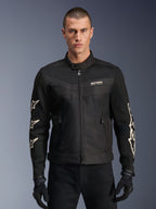 Alpinestars T-Dyno Air Jacket, czarna tekstylna kurtka motocyklowa, z białymi grafikami gwiazd na rękawach i logo na klatce piersiowej, panele z siatki zapewniające wentylację, krój motocyklowy inspirowany stylem vintage, noszona z czarnymi rękawicami i spodniami