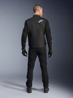 Alpinestars T-Dyno Air Jacket, czarna, widok z tyłu na modelu, tekstylna kurtka motocyklowa z panelami z siatki 3D i białym logo gwiazdy na ramieniu, noszona z czarnymi spodniami i rękawicami, nowoczesny miejski strój motocyklowy