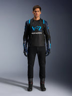 Kurtka motocyklowa Alpinestars T-Stunt Air, czarna z ciemnoniebieskimi i jasnoniebieskimi akcentami, duże białe logo na piersi, sportowy krój z siatkową konstrukcją zapewniającą przepływ powietrza, noszona z czarnymi spodniami i butami motocyklowymi dla stylowej szosowej estetyki.