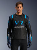 Alpinestars T-Stunt Air Jacket, motocyklowa kurtka z siatki, czarno-niebieska, noszona przez modela w czarnych spodniach i rękawicach, modułowa konstrukcja 2 w 1 z oddychającymi panelami z siatki technicznej, logo z gwiazdą na klatce piersiowej i branding Alpinestars na rękawach.
