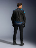 Alpinestars T-Stunt Air Jacket, modułowa tekstylna kurtka motocyklowa, czarna, ciemnoniebieska i jasnoniebieska, widok z tyłu pokazujący dolną kieszeń na plecach na rękawy z białym logo Alpinestars, noszona z czarnymi spodniami i butami.