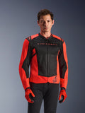 Alpinestars MM93 T-SPS Air V2 Jacket, kurtka motocyklowa, czerwona fluo i czarna, noszona przez modela z dopasowanymi czerwonymi rękawicami i czarnymi spodniami, z napisem „Marc Marquez” na klatce piersiowej i logo „93”, sportowa konstrukcja z siatki