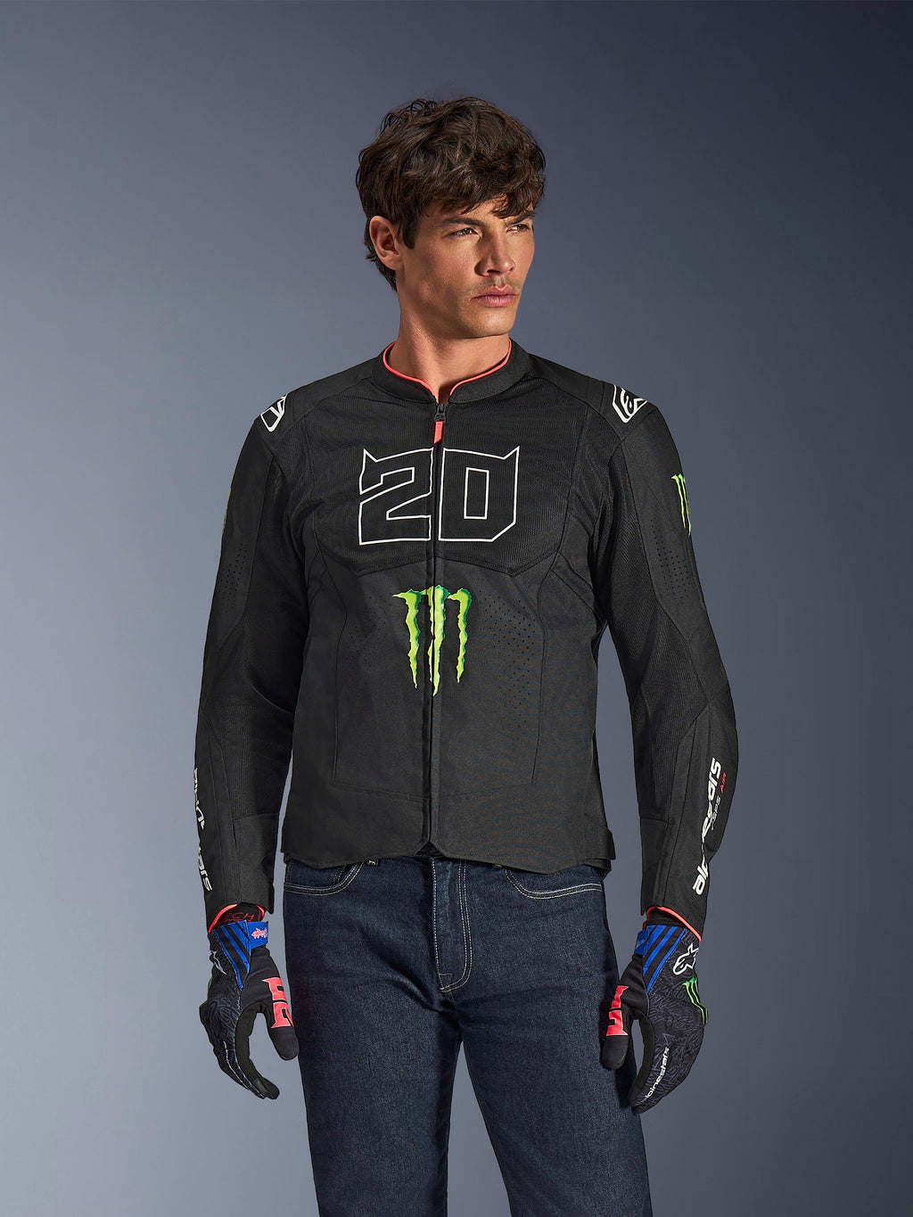 Alpinestars FQ20 T-SPS Air V2 Monster Jacket, Black motorcycle jacket with large white '20' and green Monster Energy logo, worn by a male model with dark jeans and matching gloves, lightweight mesh construction for urban riding