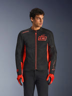 Kurtka Alpinestars MM93 C-1 Air, miejska kurtka motocyklowa, czerwona fluo i czarna, noszona przez modela z dopasowanymi czerwonymi rękawicami i czarnymi spodniami, z wyraźnym logo 93 Marca Marqueza na klatce piersiowej oraz panelami z siatki zapewniającymi przepływ powietrza