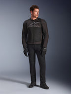 Męski model w kurtce motocyklowej Alpinestars SMX Air, kolor Black Anthracite, wentylowane panele z siatki i szare logo na klatce piersiowej, czarne spodnie i rękawice ochronne, tło studyjne z gradientem