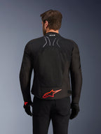 Kurtka Alpinestars SMX Air, widok z tyłu, czarna z jaskrawoczerwonym logo Alpinestars na dole pleców, z technicznym panelem z siatki o wysokim przepływie powietrza i oznaczeniem Tech-Air Ready, noszona przez motocyklistę w czarnych spodniach i rękawicach
