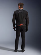 Alpinestars SMX Air Jacket, czarna z jaskrawoczerwonym logo, widok z tyłu ukazujący oznaczenie Tech-Air Ready i siatkowe panele wentylacyjne, noszona z czarnymi spodniami i rękawicami, wysokiej klasy sportowa i wyścigowa odzież motocyklowa