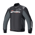 Alpinestars Monza Sport Jacket, tekstylna kurtka motocyklowa w kolorze czarnym i szarym, wysoki kołnierz z napisem „ONE GOAL. ONE VISION.”, białe i szare logo Alpinestars na piersi, logo gwiazdy na ramionach, czerwone akcenty graficzne, regulowane paski w talii, smukły design techniczny