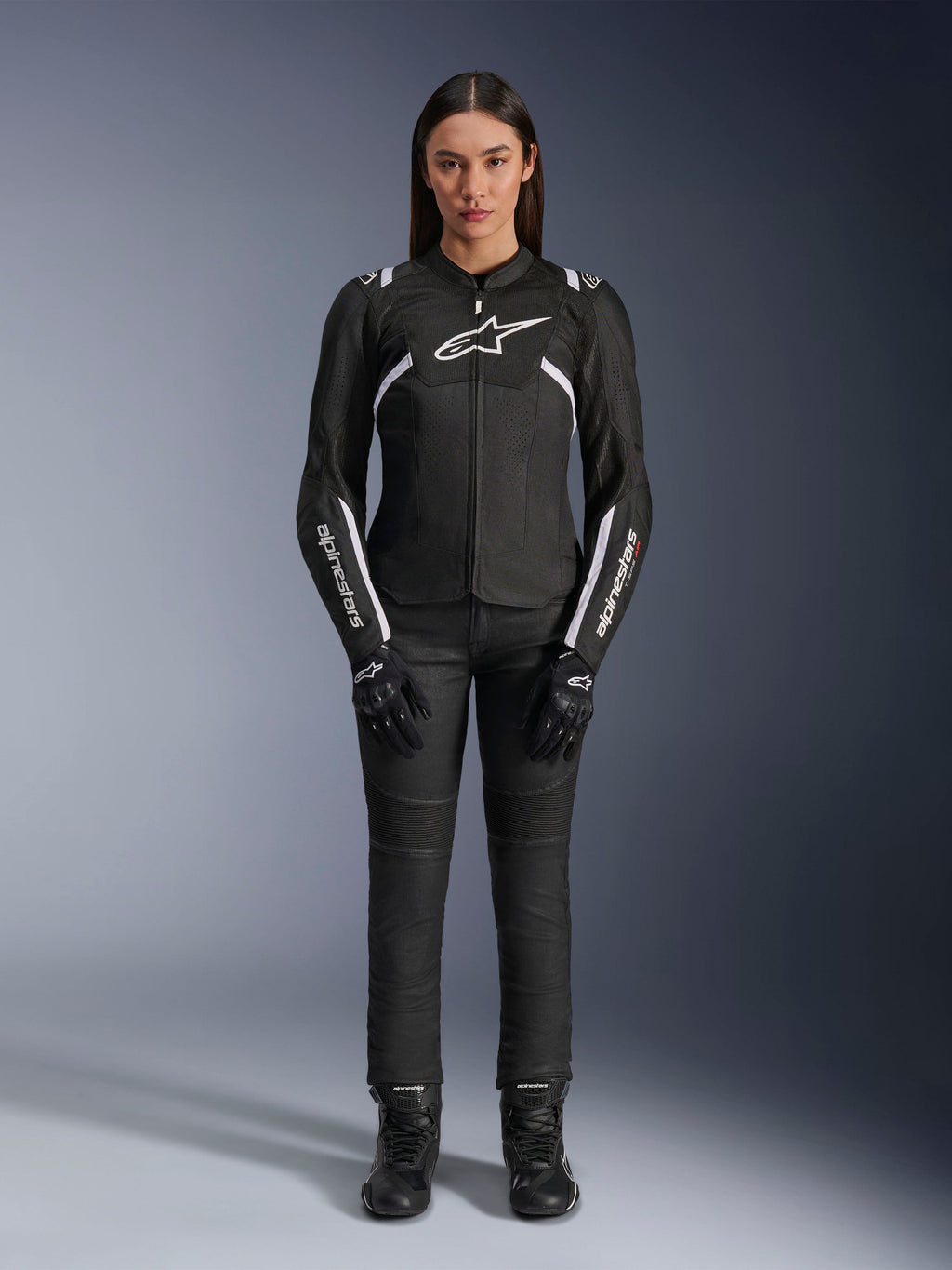Alpinestars Stella T-Sps Air V2 Jacket, damska kurtka motocyklowa, czarno-biała, z panelami z siatki i białymi akcentami, noszona z czarnymi spodniami, rękawicami i butami, sportowy krój do jazdy miejskiej