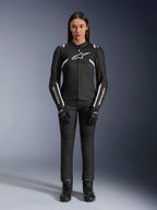 Alpinestars Stella T-Sps Air V2 Jacket, damska kurtka motocyklowa, czarno-biała, z panelami z siatki i białymi akcentami, noszona z czarnymi spodniami, rękawicami i butami, sportowy krój do jazdy miejskiej