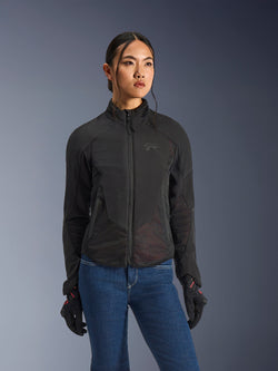 Kurtka Alpinestars Stella Aeroshell Airflow, damska kurtka motocyklowa, kolor czarny antracyt, noszona przez modelkę z niebieskimi dżinsami i czarnymi rękawicami, wyposażona w laserowo perforowany softshell i panele z siatki dla wysokiego przepływu powietrza, ergonomiczny sportowy design.