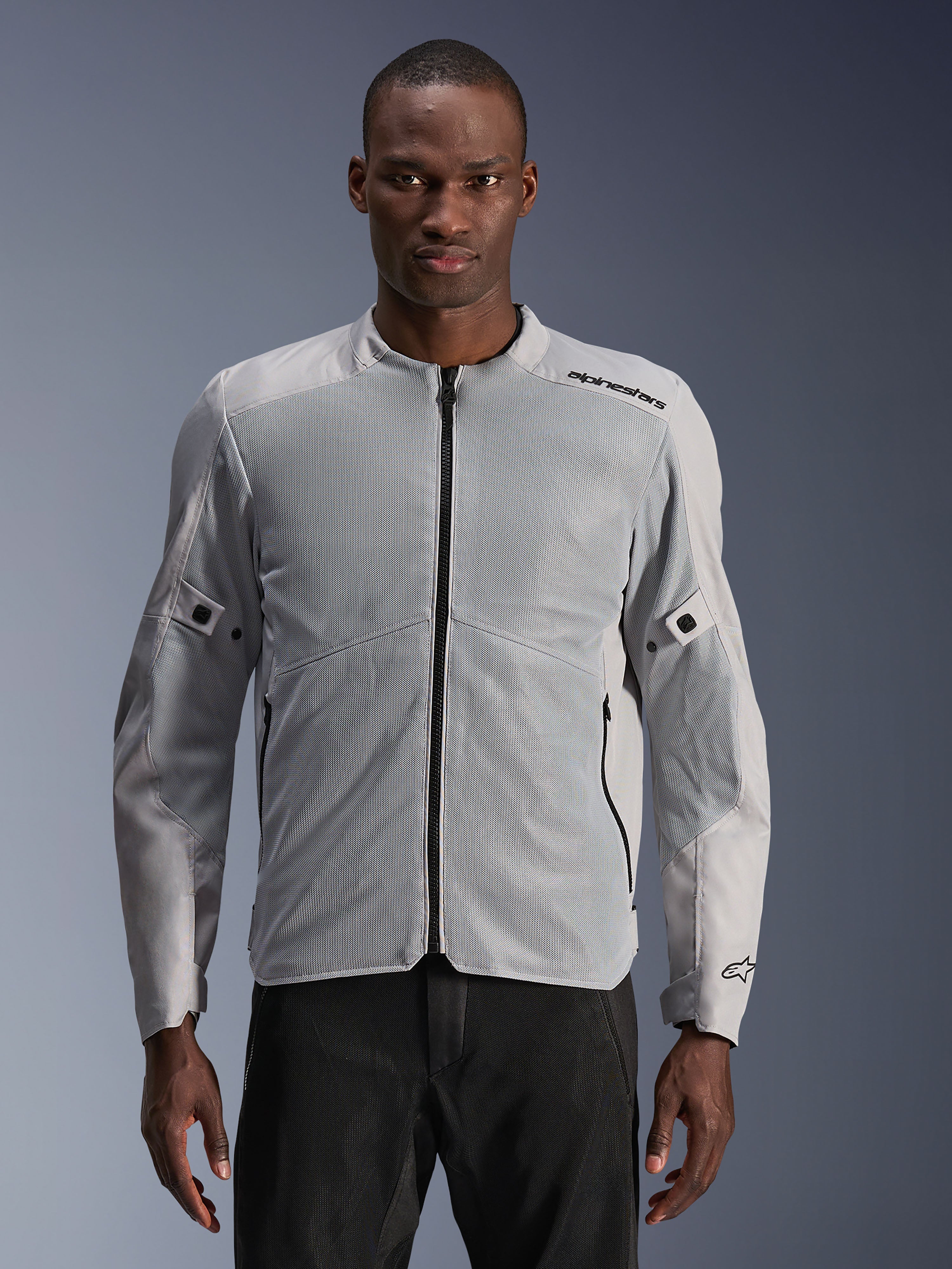 Alpinestars C-1 Air Jacket, miejska kurtka motocyklowa, srebrna i szara, z dużymi panelami z siatki technicznej na klatce piersiowej i rękawach, czarny centralny zamek błyskawiczny, minimalistyczne logo na ramieniu, lekka i wentylowana konstrukcja do miejskich dojazdów